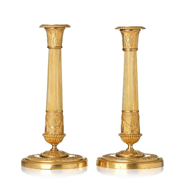 A pair of French Empire ormolu candlesticks, early 19th century.