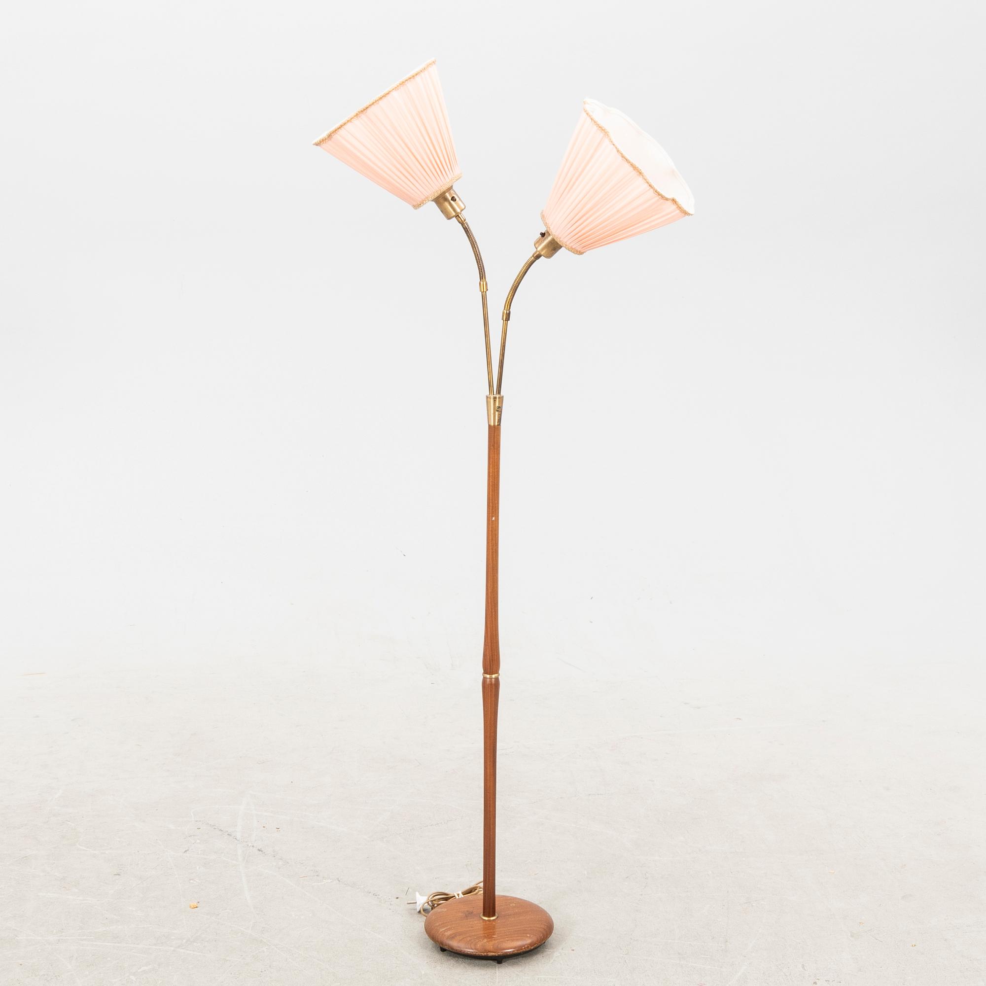 A teak and brass floor lamp from the first half of the 20th century.