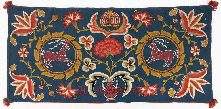 An embroidered Carriage cushion, c 102 x 48 cm Wemmenhög district, southern Skåne, first quarter of the 19th century.