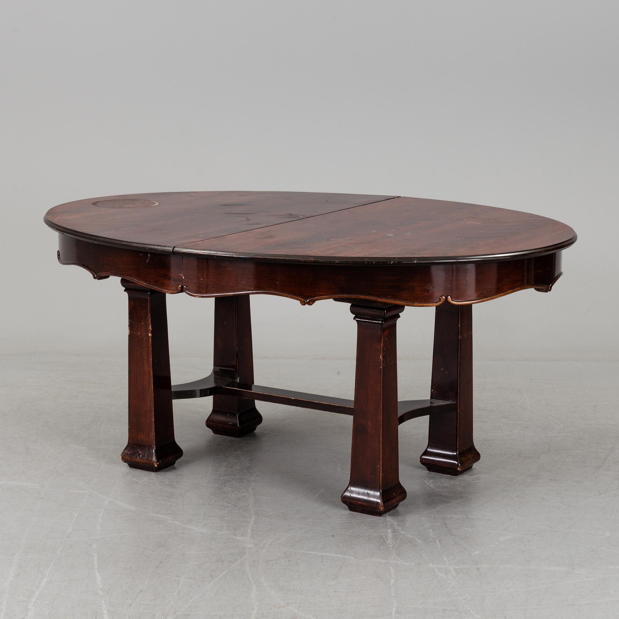 A late 19th century dining table with ten chairs and five extension leaves.