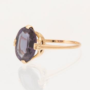 An 18K gold ring set with a synthetic colourchange purple sapphire.