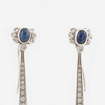 A pair of 18K gold earrings with emeralds, sapphires, and round brilliant-cut diamonds.