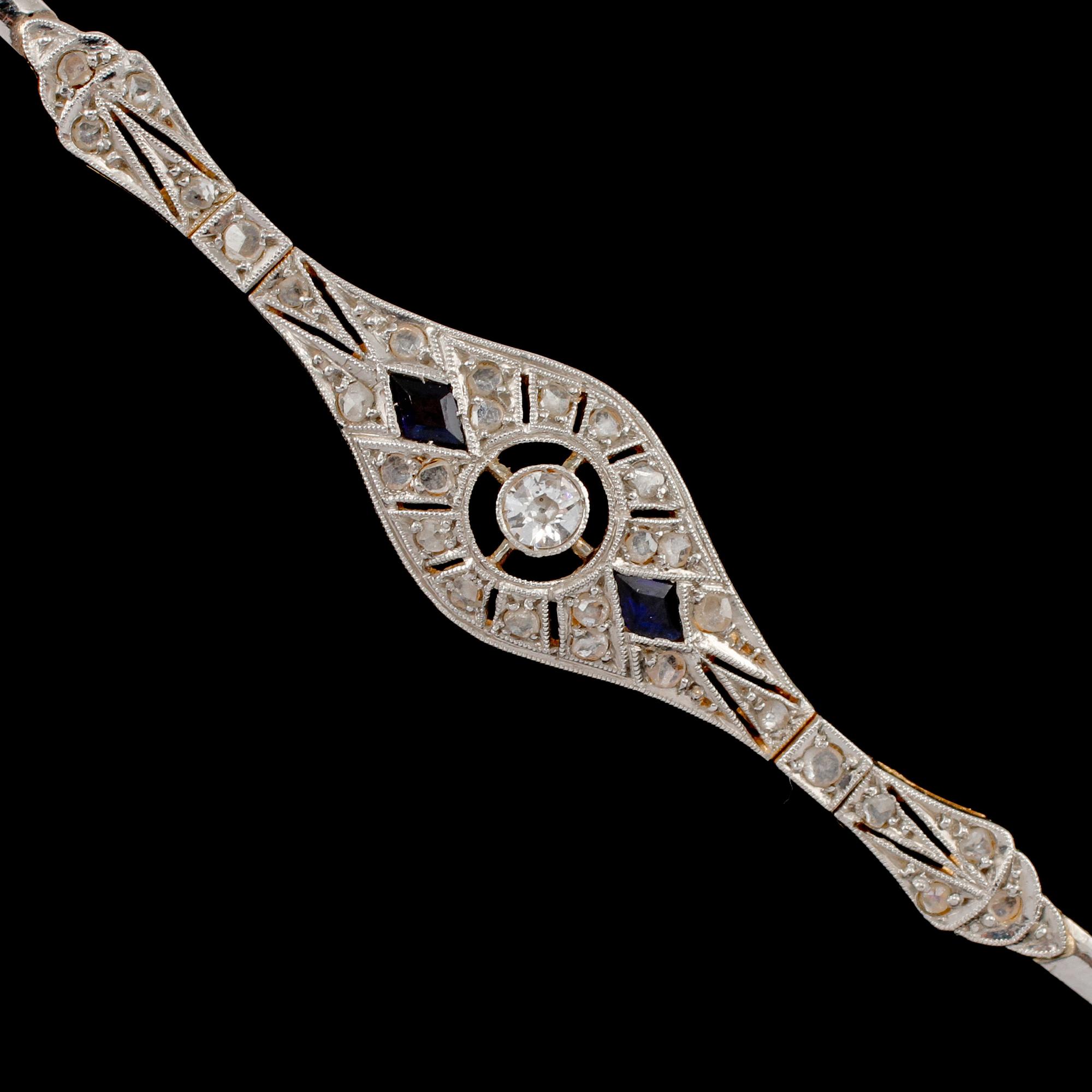 ARMBAND, 18k guld, fasettslipad diamant ca 0.08 ct, 2 blå safirer samt rosenstenar, 1900-talets första hälft. Vikt 8 g.