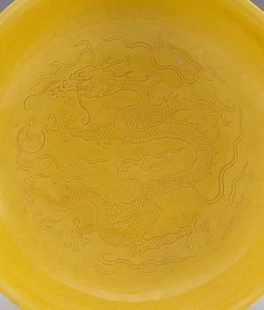 A pair of yellow-glazed incised dragon dishes, Qing dynasty with Qianlongs seal mark (1644-1912).
