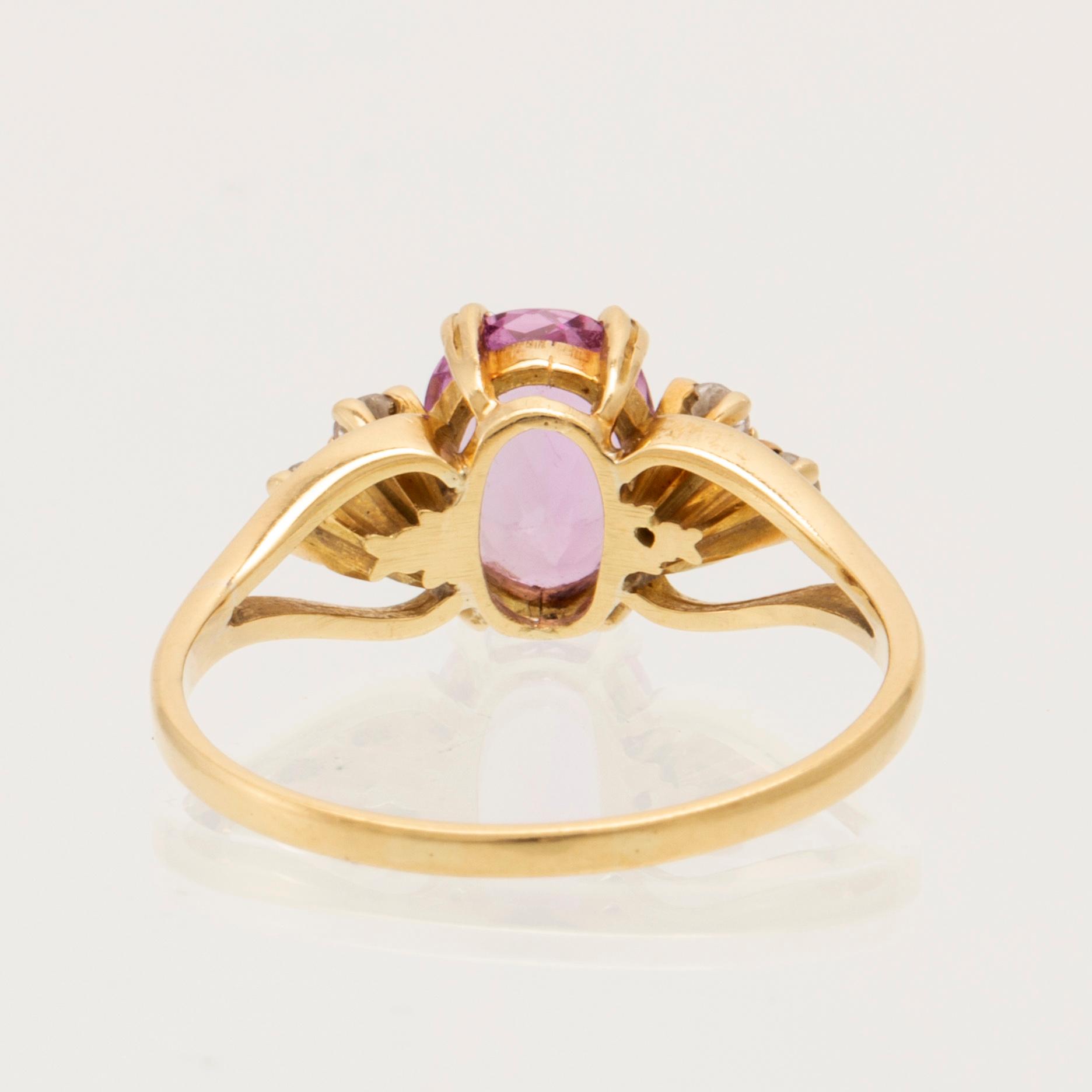 Ring 18K guld med oval fasetterad rosa ädelsten samt runda briljantslipade diamanter.