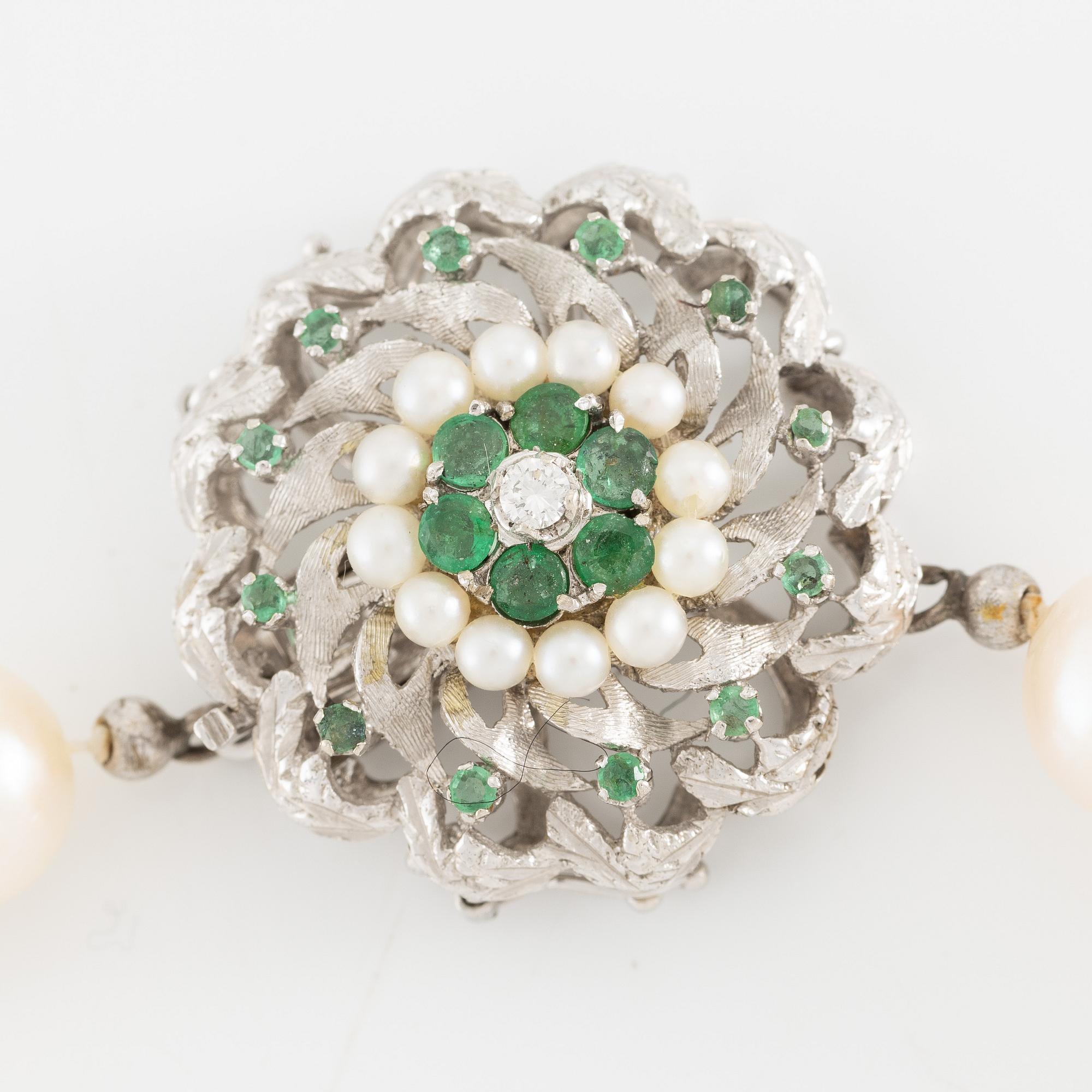 Pearl necklace, cultured pearls with a clasp in 18K white gold set with emeralds, diamonds, and pearls.