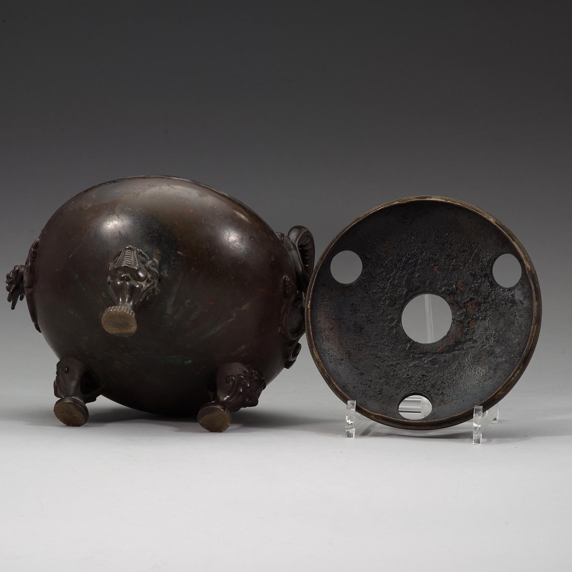 A bronze tripod censer with cover and stand, Qing dynasty, 17/18th Century.