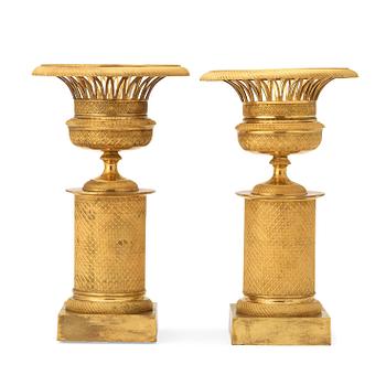 1296. A pair of French Empire early 19th century gilt bronze urns.