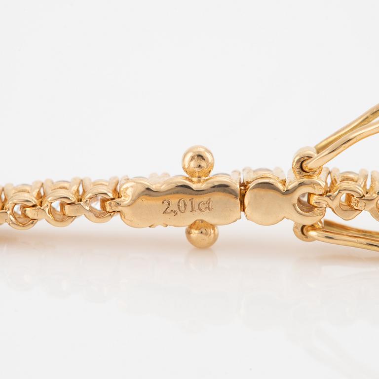 A tennis bracelet in 14K gold with round brilliant-cut diamonds.