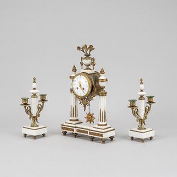 A Louis XVI style pendulum clock and a pair of candelabra, early 20th century.