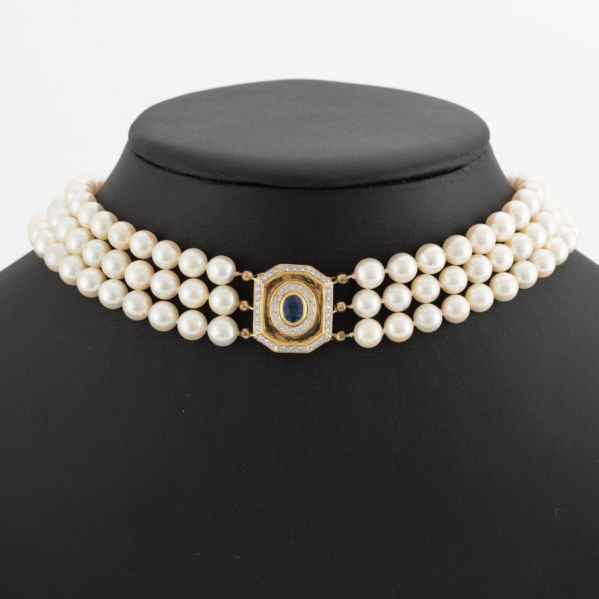 Pearl necklace, three strands of cultured pearls, with a clasp in 18K gold set with a sapphire and brilliant-cut diamonds.