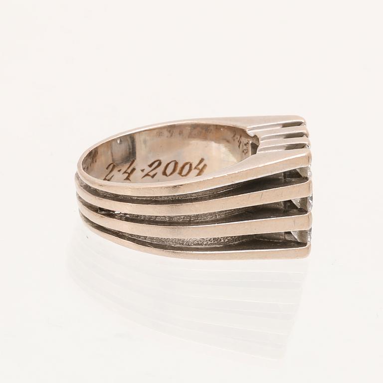 A 21K white gold ring with round briliant cut diamonds.