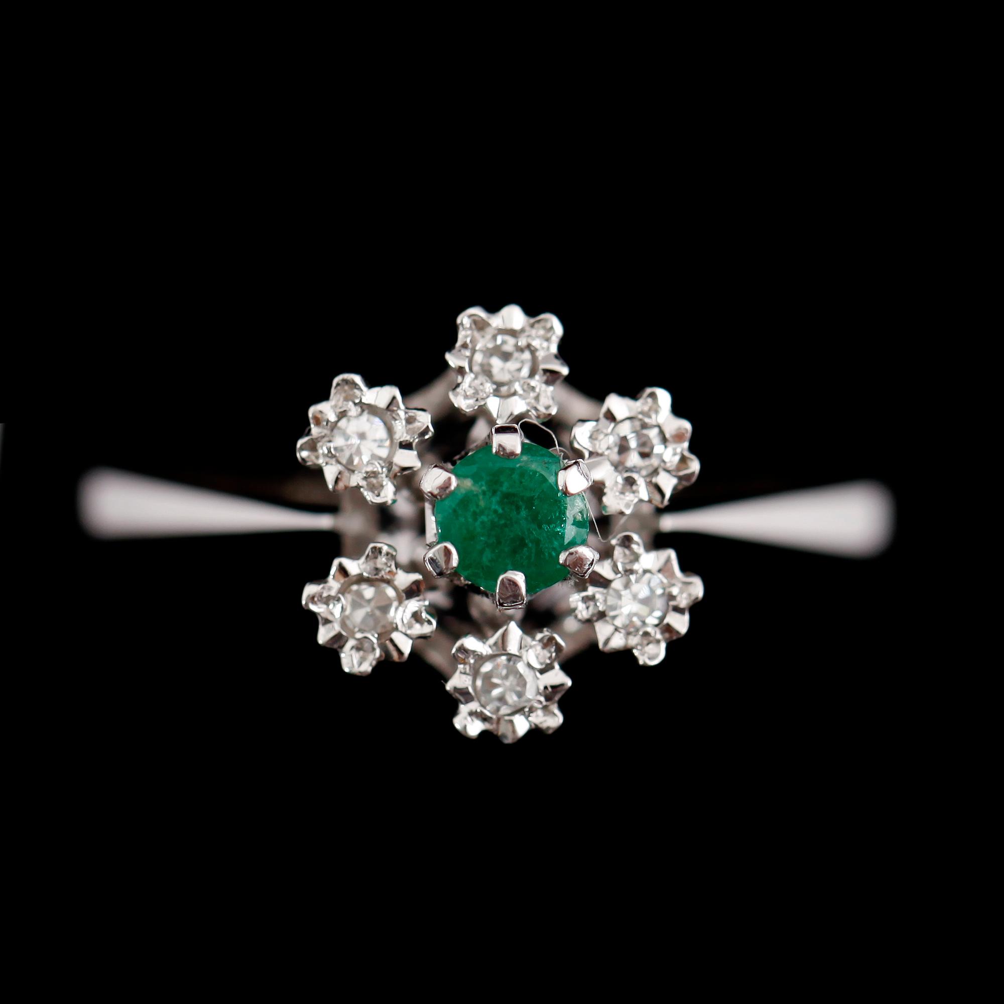 RING, 18 k vitguld, smaragd och 6 mindre briljantslipade diamanter.