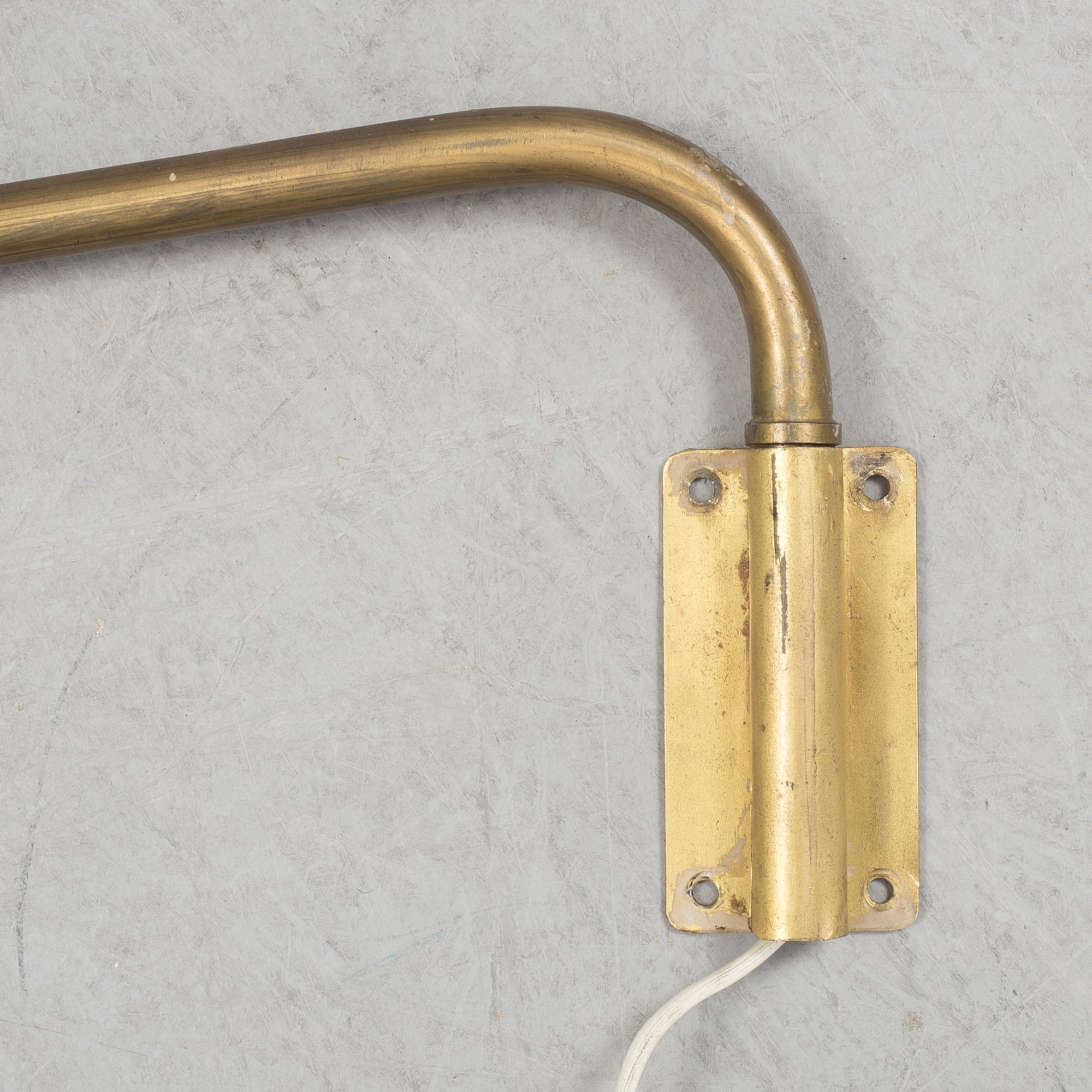 A 20th century brass and painted metal swing-arm wall light.