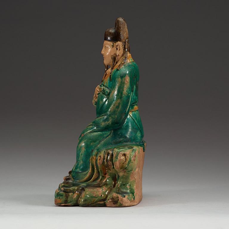 A green and yellow glazed figure of a seated deity, Ming dynasty (1368-1644).