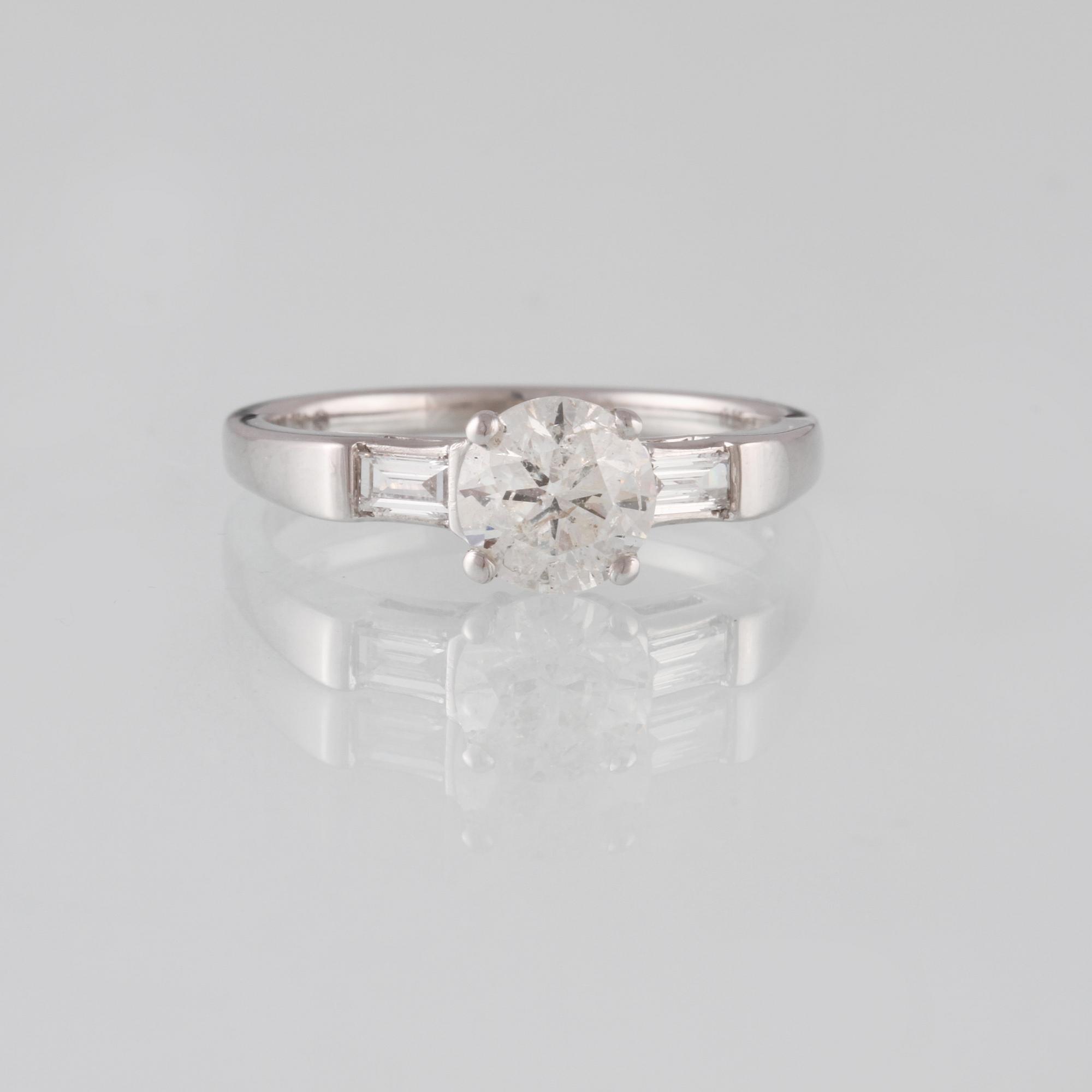 RING, 18K vitguld med briljantslipad diamant 1.14 ct samt 2 baguetteslipade diamanter 0.20 ct. Vikt 3,5 gram.