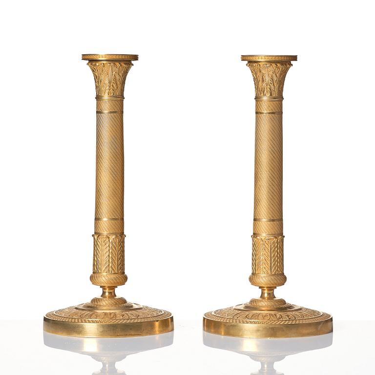 A pair of French Empire ormolu candlesticks, early 19th century.