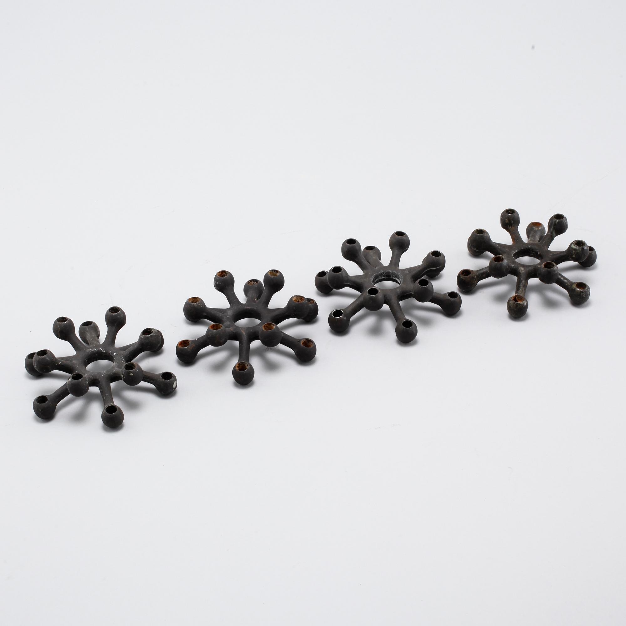 Four 1960s iron cast candle holders, designed by Jens Quistgaard for Dansk Designs .