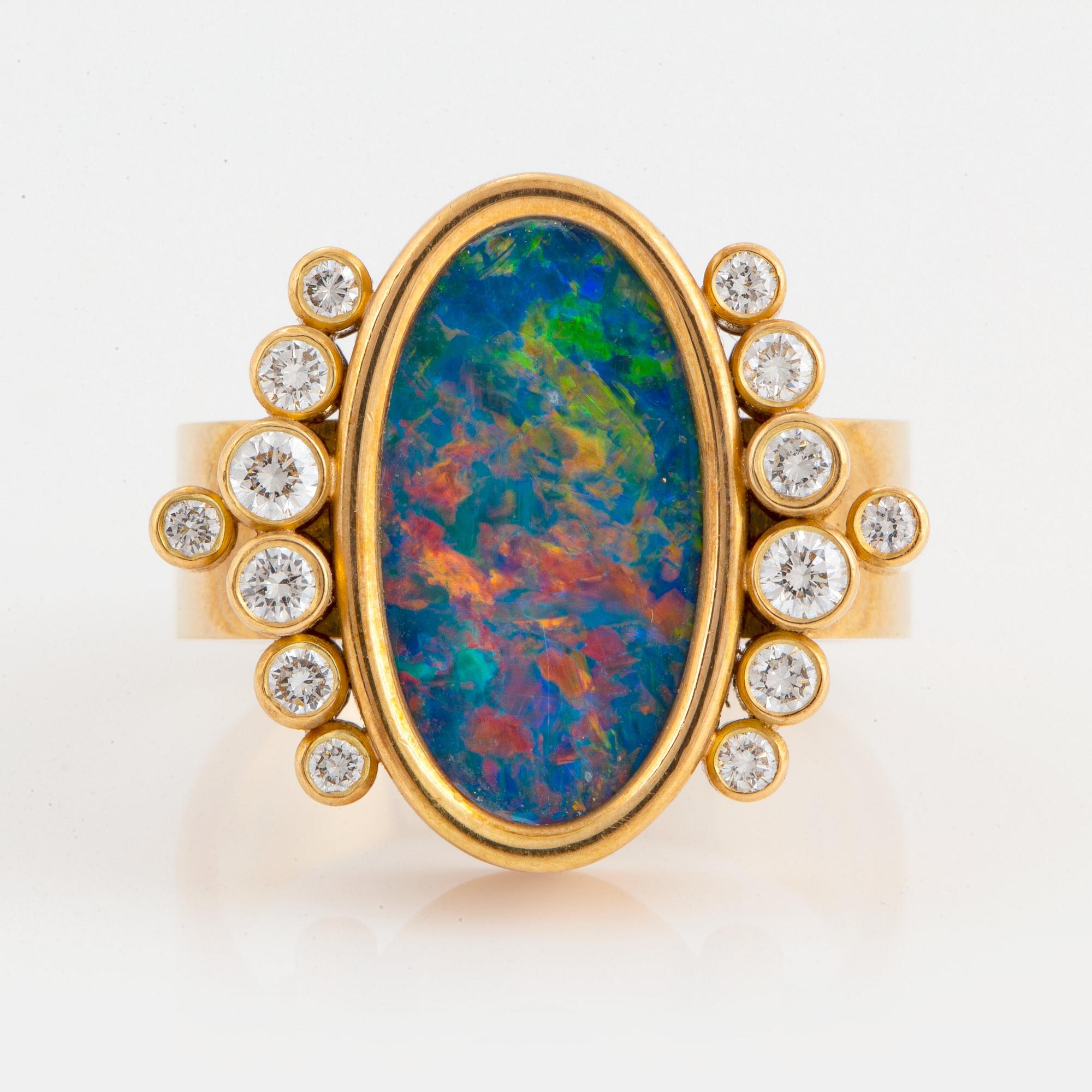An 18K gold and opal ring set with round brilliant-cut diamonds.