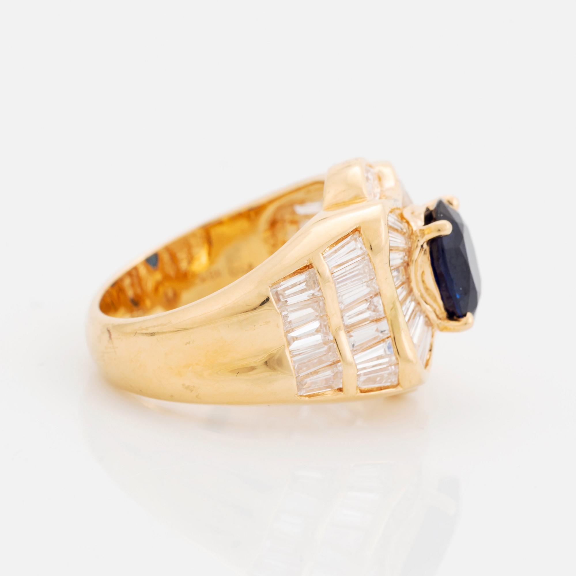 An 18K gold Junod ring set with a facted sapphire and tapered baguette-cut diamonds.