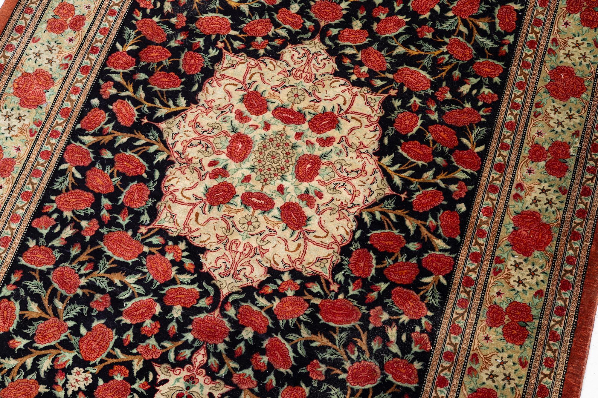 A signed silk Qum rug. c. 154 x 103 cm.