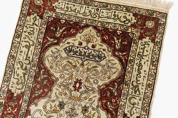 A silk and metal Hereke rug, c. 80 x 51 cm.