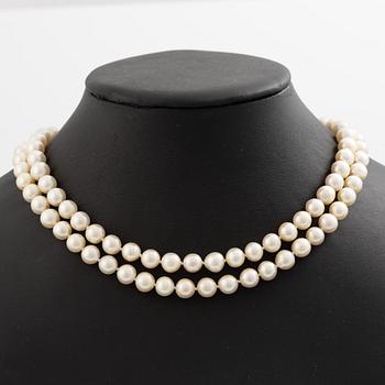 Pearl necklace, two-stranded, with a clasp by Seblings in 18K gold set with emeralds, rubies, and brilliant-cut diamonds.
