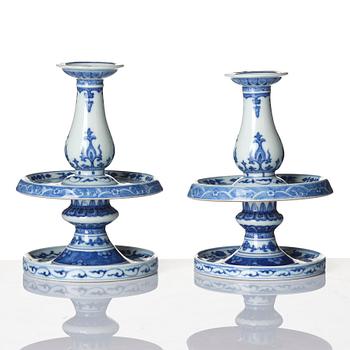 A pair of blue and white pricket candle sticks, with a poem, Qing dynasty with a Qianlong mark and of the period.