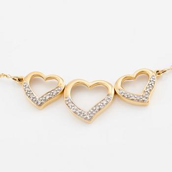 Necklace, 18K gold with a decoration of three hearts with small diamonds.