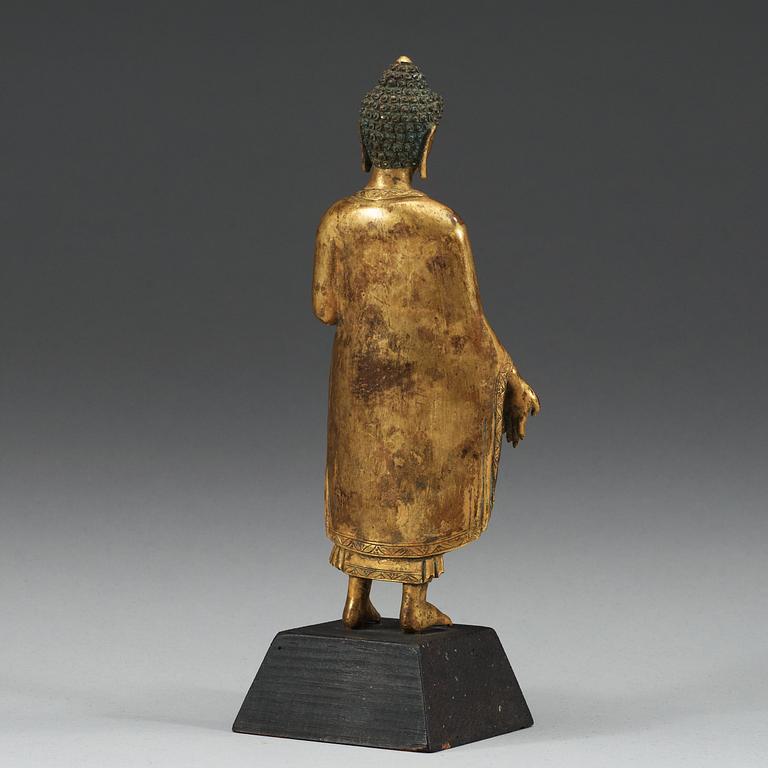 A standing gilt bronze figure of Buddha, Nepal, 19th Century.