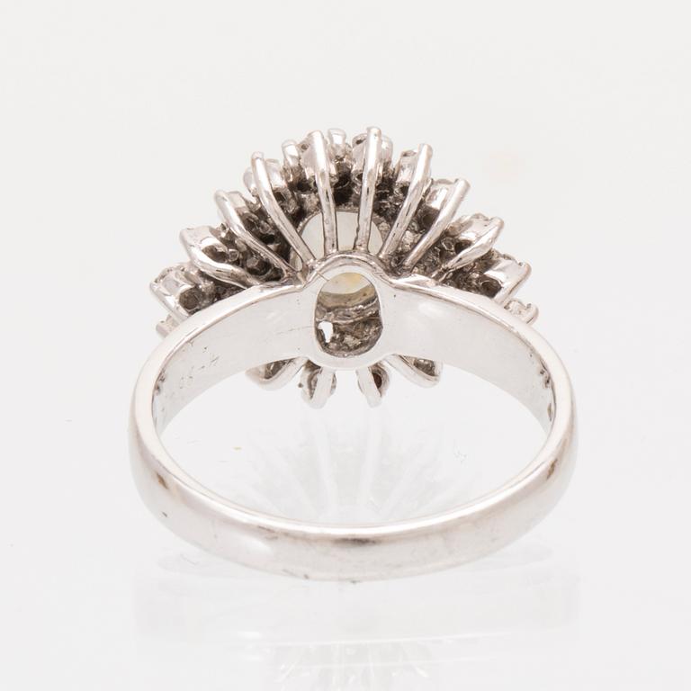 An 8K white gold ring set with a gray cabochon cut star sapphire and single cut diamonds.