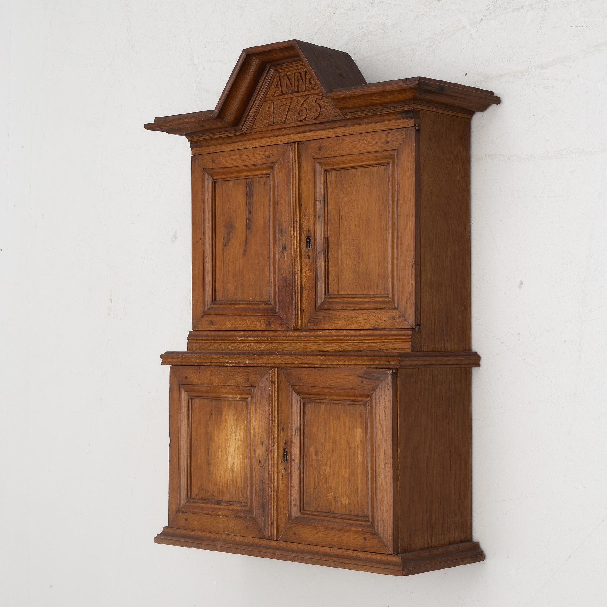 A wall cabinet, dated 1765.