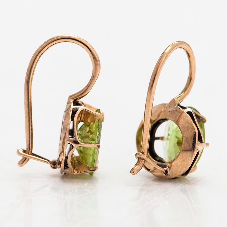 A pair of 14K gold earrings with peridots.