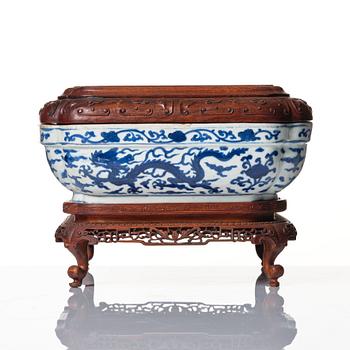 A blue and white quatrefoil dragon box with wooden cover and stand, Ming dynasty, Wanli mark and period (1573-1620).