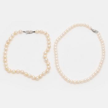 Two cultured pearl necklaces with silver clasps.