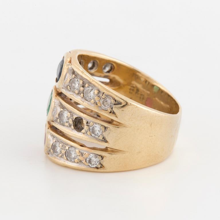 An oval cut ruby, sapphire and emerald ring, surrounded by brilliant cut diamonds.