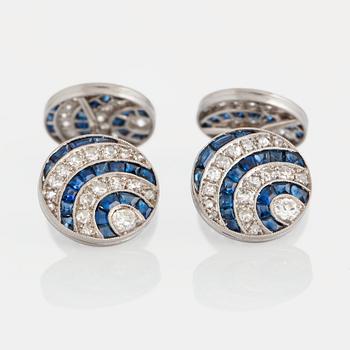 A pair of cufflinks in platinum and 18K white gold set with diamonds of various cuts and sapphires.