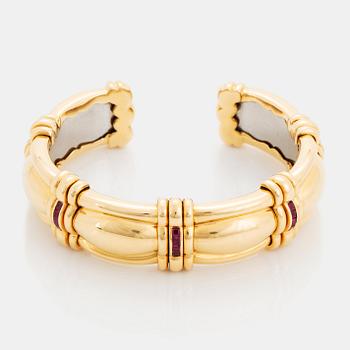 424. An 18K gold bracelet set with step-cut rubies.