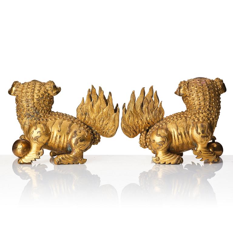 A pair of gilt bronze scultpures of buddhist lions, 18/19th Century.