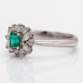 A platinum ring, with an emerald and brilliant- and marquise-cut diamonds.