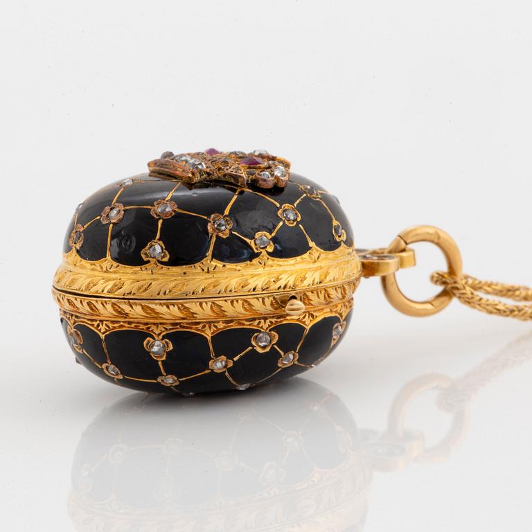 An egg shaped locket in 18K gold and black enamel set with rose-cut diamonds and rubies.