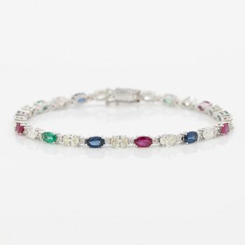 Bracelet 18K white gold set with faceted rubies, emeralds, sapphires, and round brilliant-cut diamonds.