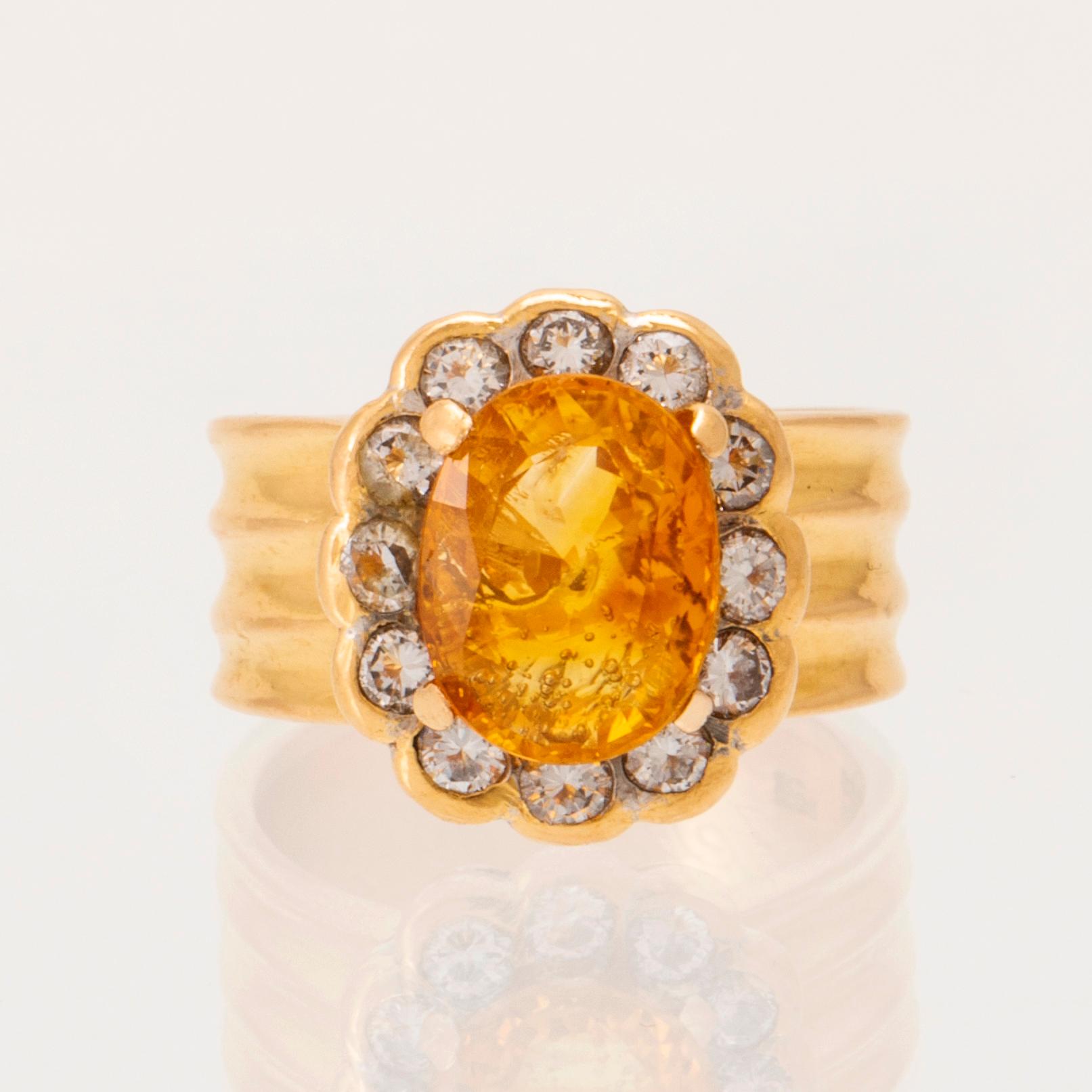 A 22K gold carmosé ring with an oval faceted yellow sapphire and round brilliant-cut diamonds.
