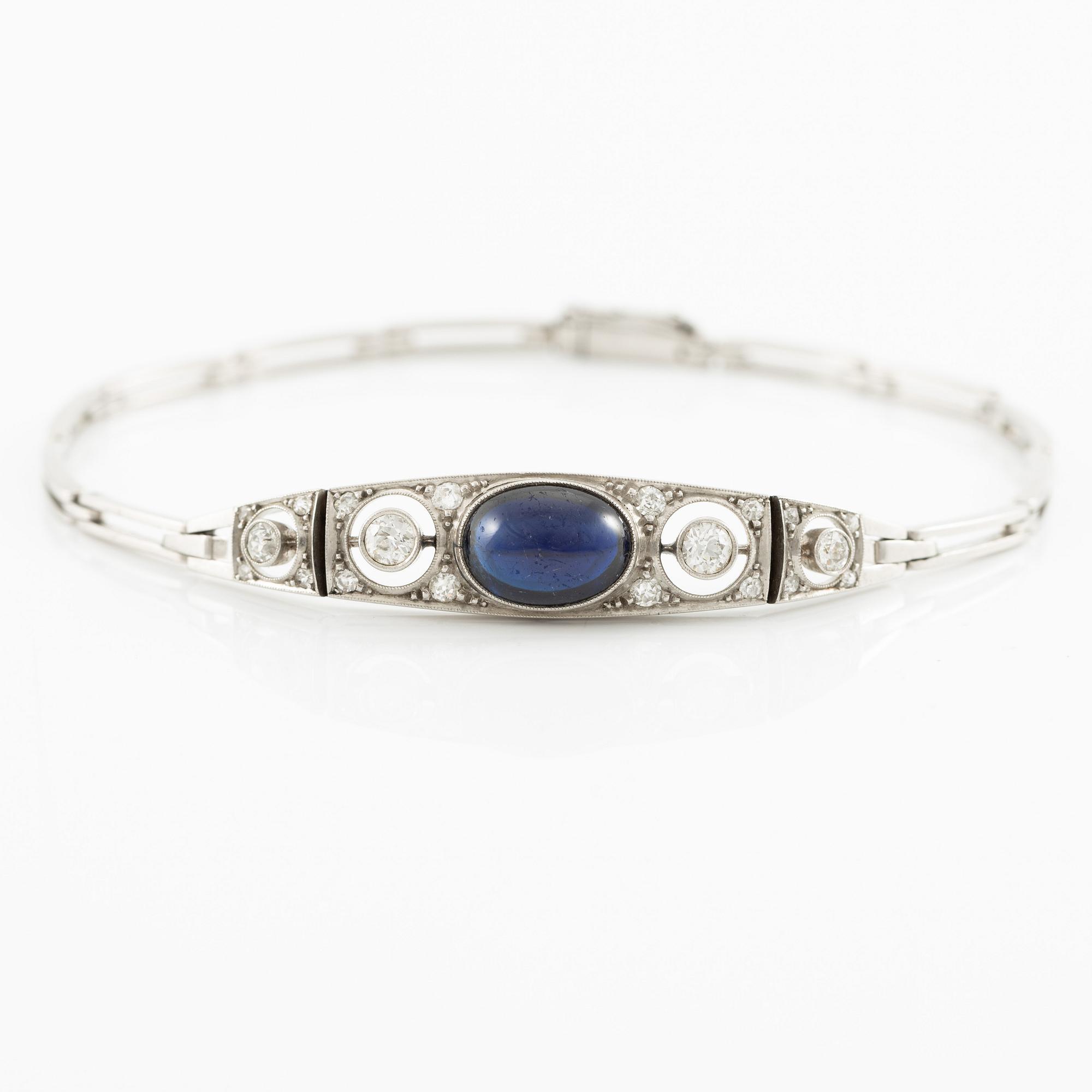 A bracelet in platinum set with old-cut diamonds and a blue stone.