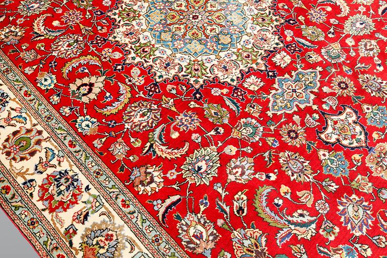 A signed Tabriz carpet, ca 336 x 223 cm.