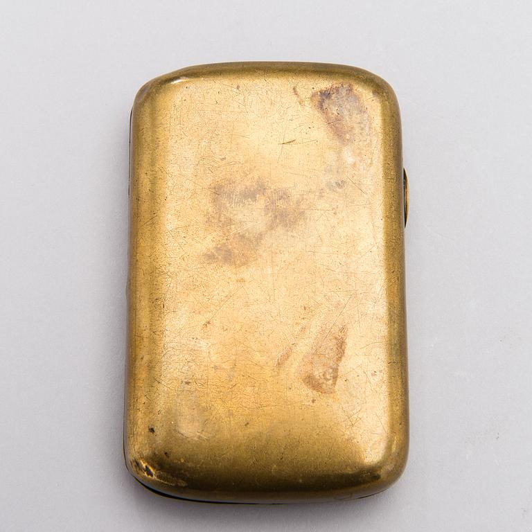 A BRASS FABERGÉ CIGARETTE CASE, 1914-1915.