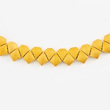 Garnityr av guldsmycken, en collier (14K), ett armband (18K), ett par örhängen (14K) och en ring (14K).