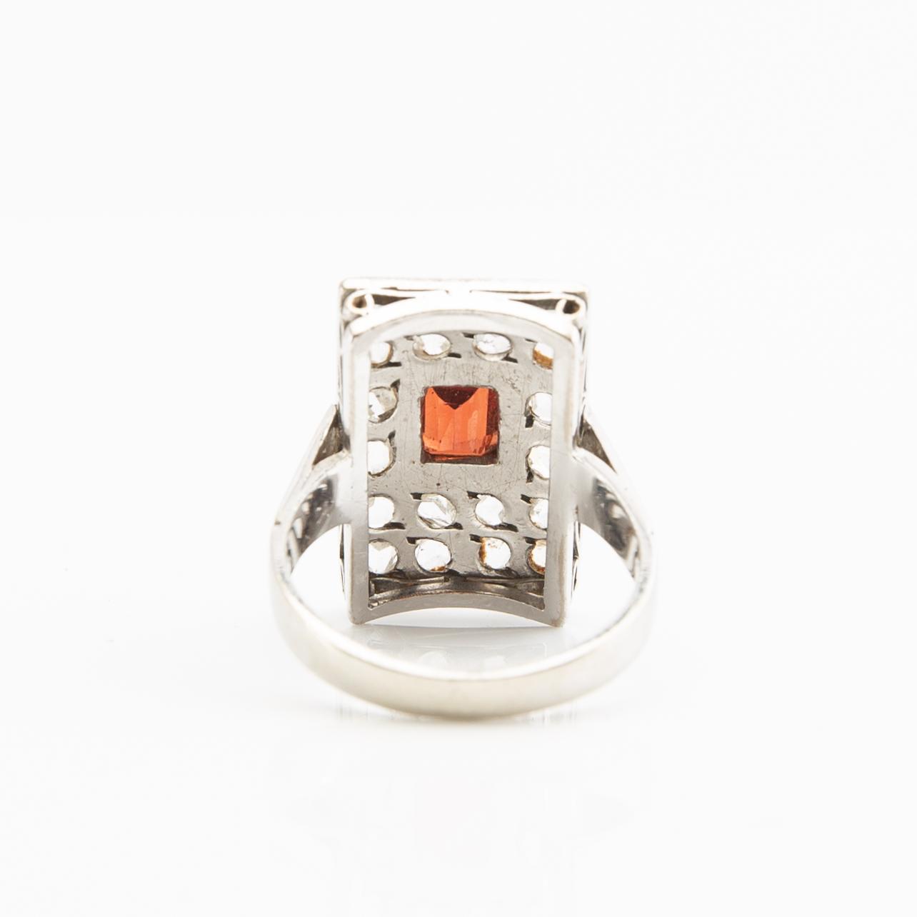 Ring, 18K white gold with a red stone (possibly garnet) and diamonds.