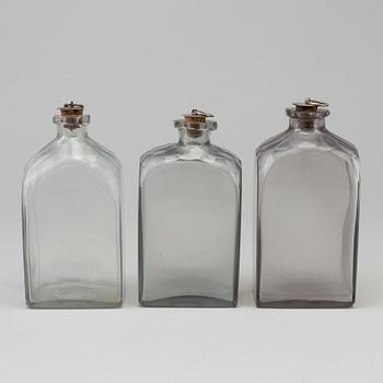 A mid 19th century mahogany veneered box with three glass bottles.