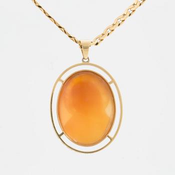 An 18K gold chain and pendant set with a shell cameo.